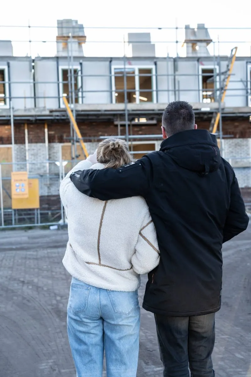 Een stel bij hun nieuwbouwwoning in aanbouw
